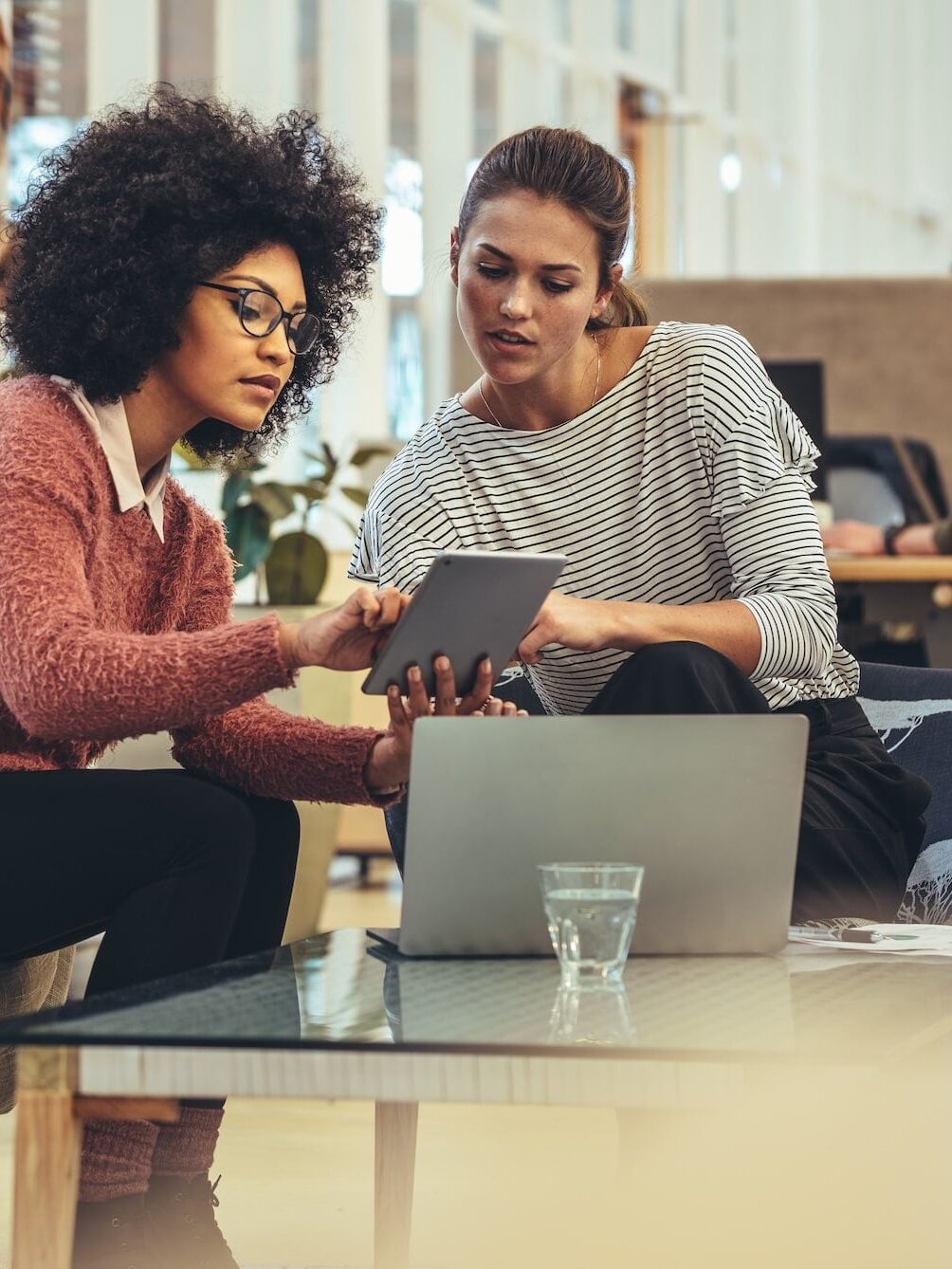 Female coworkers discussing work in office